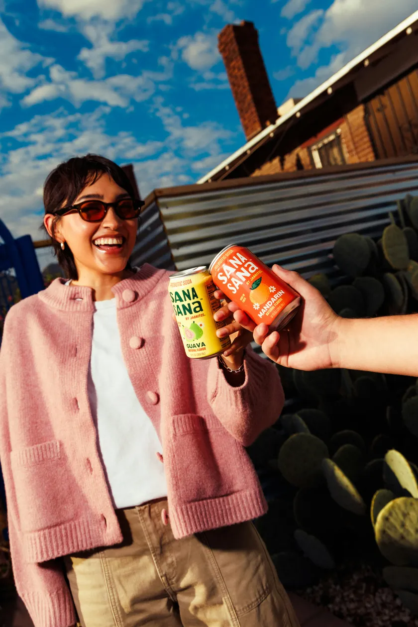 Two people knocking cans together, both labelled front and back