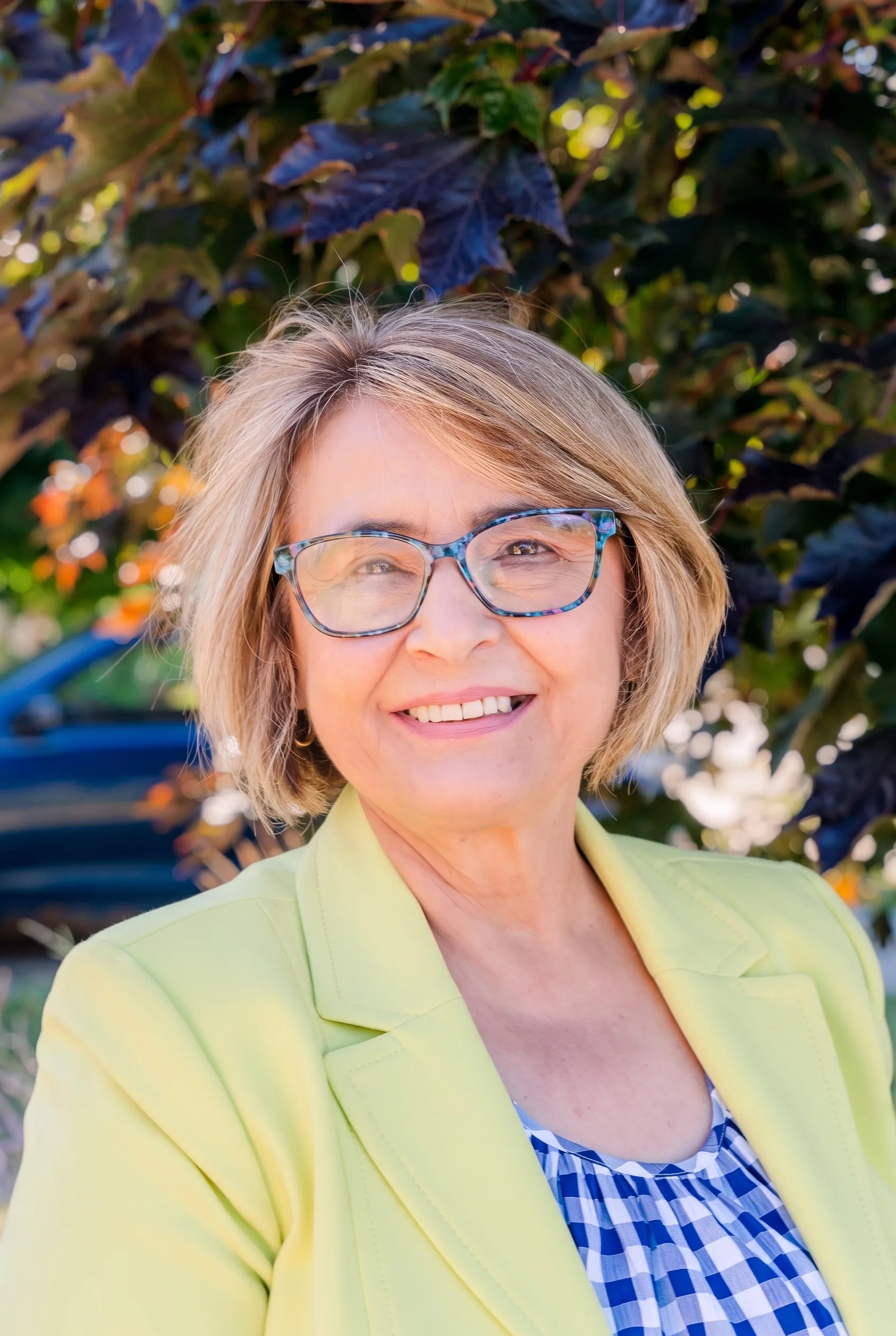 Valentina Constantinescu, founder of Greens4U, smiling in a yellow blazer outdoors